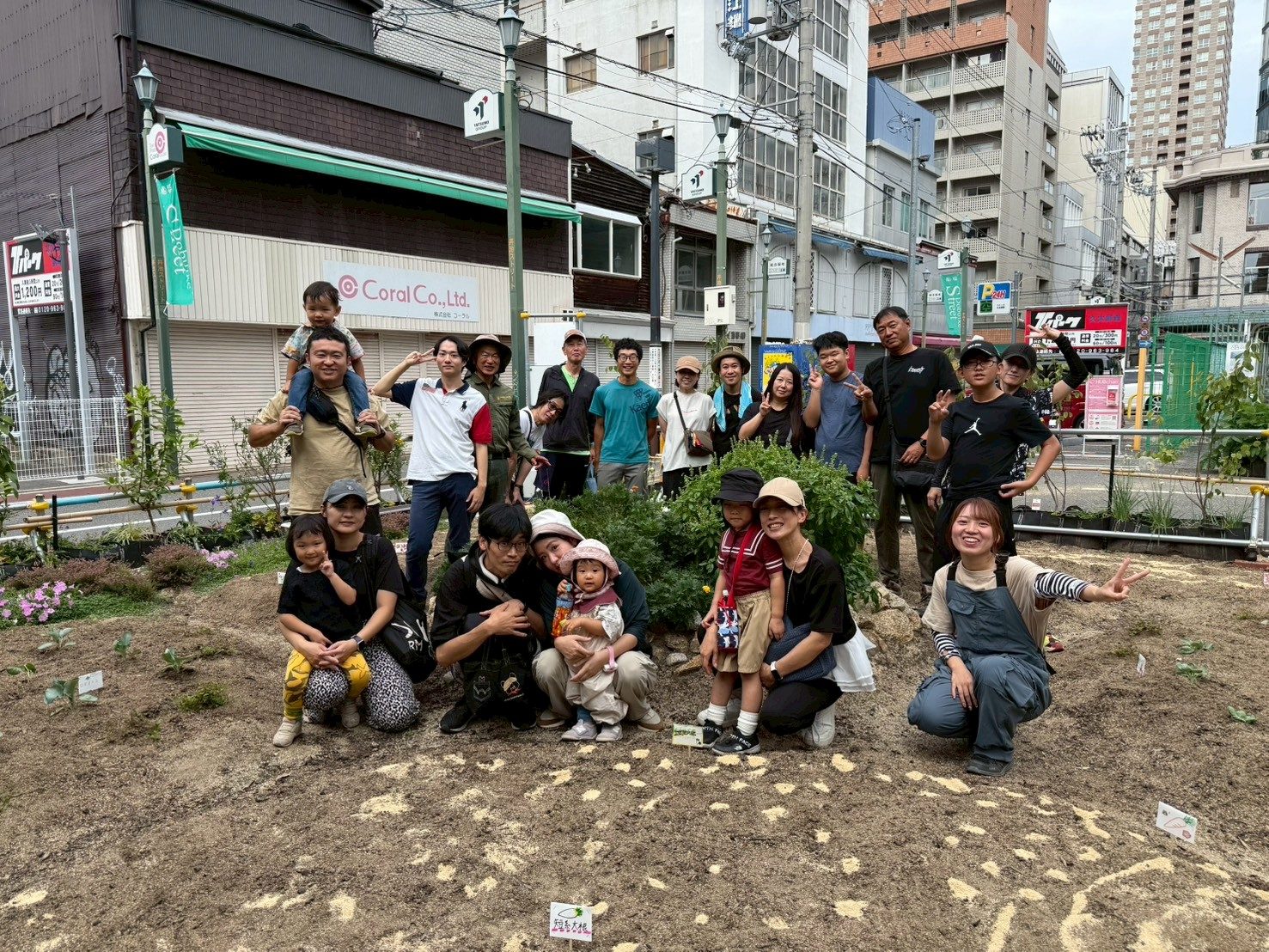 畑を囲んで笑顔で集まるcoton なかせんばのメンバーと子どもたち